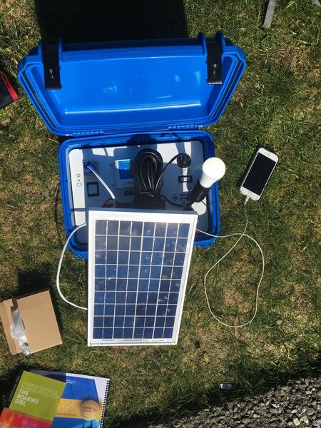 File:Solar suitcase w panel charging phone.jpg