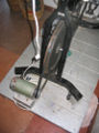 A fan belt is wrapped around the flywheel of an exercise bike and the pulley of high voltage, low rpm permanent magnet dc generator. 110v blenders and some other low power ac appliances can be powered provided they are built using universal motors which run on ac or dc. The next stage of development of this project is to mount the generator directly to the frame of the exercise bike via a gravity tensioned swing arm. This will eliminate the need for the heavy wooden pedistle upon which the generator is currently mounted. The electrical wiring should be brought up to code. Transparent lexan-polycarbonate finger gaurds should be installed to prevent children from catching their figures between the fanbelt, pulley and flywheel. Lastly, large caster wheels should then be mounted to the base of the exercise bike's frame so that the devise can be moved easily. Because of the redundant nature of an exercise bike as compared to a bicycle that is used for transportation, a system should be designed that incorporates a blender, powered by a generator mounted on a bicycle that tows an ice-box trailer.