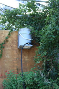 Figure 2: The existing 5-gallon storage bucket is the system's water source. The storage bucket is mounted to the retaining wall above garden beds.[1]