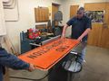 Using machine saw to cut the sign in half