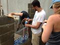 Brandon, Luis y Justine llenan la capa inferior de botellas de agua.