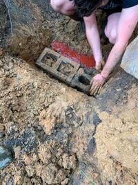 Image 6. Constructing Pond wall & Covering the electrical line with red dyed cement.