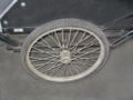 A garden cart wheel is attached to a 3/4 inch axle. The axle is suspended on a leaf springs which are attached to the frame of the trailer. Motorcycle wheels similiar to those used on the trike would be better suited for for this purpose.