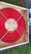 Obtain 100 feet of 1/2" diameter PEX tubing. Coil the tubing within the 36" x 36" box. Secure the coil with wooden dowels in an X Position. Drill the two 3/4" holes on opposite sides of the box to allow for the tubing to enter and exit the box.