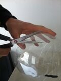 Second, use the scissors to cut thin strips from the top of the bottle downwards.