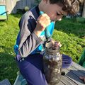 Kids using the trowel to stir the first jar.
