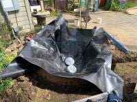 Image 10. Settling the liner in the pond using sandbags to weigh it down and make the process easier.