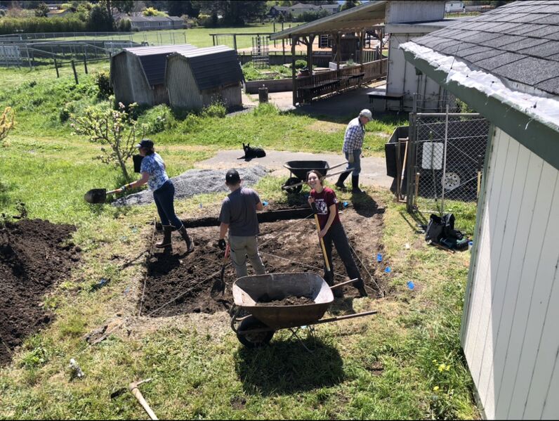 File:Katie and Rotary Club volunteers digging a leveled six inches deep for the foundation of the storage tank.jpg