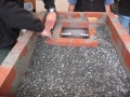 After all three courses of brick were securely in place, the mold was filled with gravel up to the top of the second course. This should approximately coincide with the top of the second course of combustion chamber