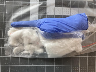 The appendix-cecum complex with a cotton mesoappendix and an embedded vessel-loop appendiceal artery before plastic-wrap closure.