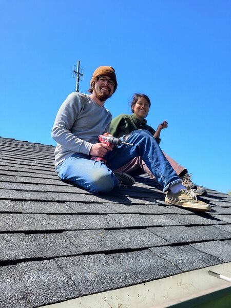 File:Klara and James on the roof ready to install gutter screen.jpg