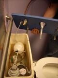 Fig 10: Junta el tubo pequeño de vinil al tubo de entrada de agua, y luego pasa los dos tubos por el tubo de aluminio. Aquí es por donde el agua de tu drenaje va a salir. Nota que las dos botellas de 32 onzas en el tanque del inodoro sirven pare disminuir la cantidad de agua usada para descargar el inodoro.