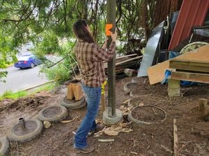 Marci leveling the 4"x4" foundational posts
