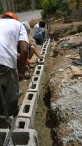 Laying the first row of blocks on the front trench.