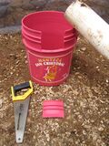 From these materials, we see the beginnings of our overflow system. Using a saw, a length of 4.5 meter PVC, and a 20 gallon bucket (which ironically held pig lard prior to its reappropriation as a Biol receptacle), we constructed a mouth on the rim of the bucket to accept the PVC from which will flow the Biol towards the second drainage bucket.