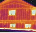 A thermal image of heat escaping through the walls of a wood-frame house (red/orange indicated heat escape). Image credited to: Logix ICF