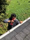 Victor drilling holes to be able to ziptie the gutter screen.