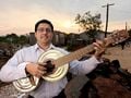 איור 1: Favio Chavez עם גיטרה ממוחזרת בעבודת יד