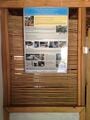 Saman balyalarından yapılmış ev hakkında bilgi veren bir poster.