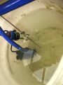 This photo shows the water heater with the red temperature ring, the thermometer, and the water pump. It is time to clean this reservoir.