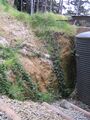 The steepest part of the slope is next to the water tank.