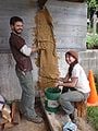 Adam and Mitra prepare the burlap sack and clay idea to help the cob wall stick the the concrete wall
